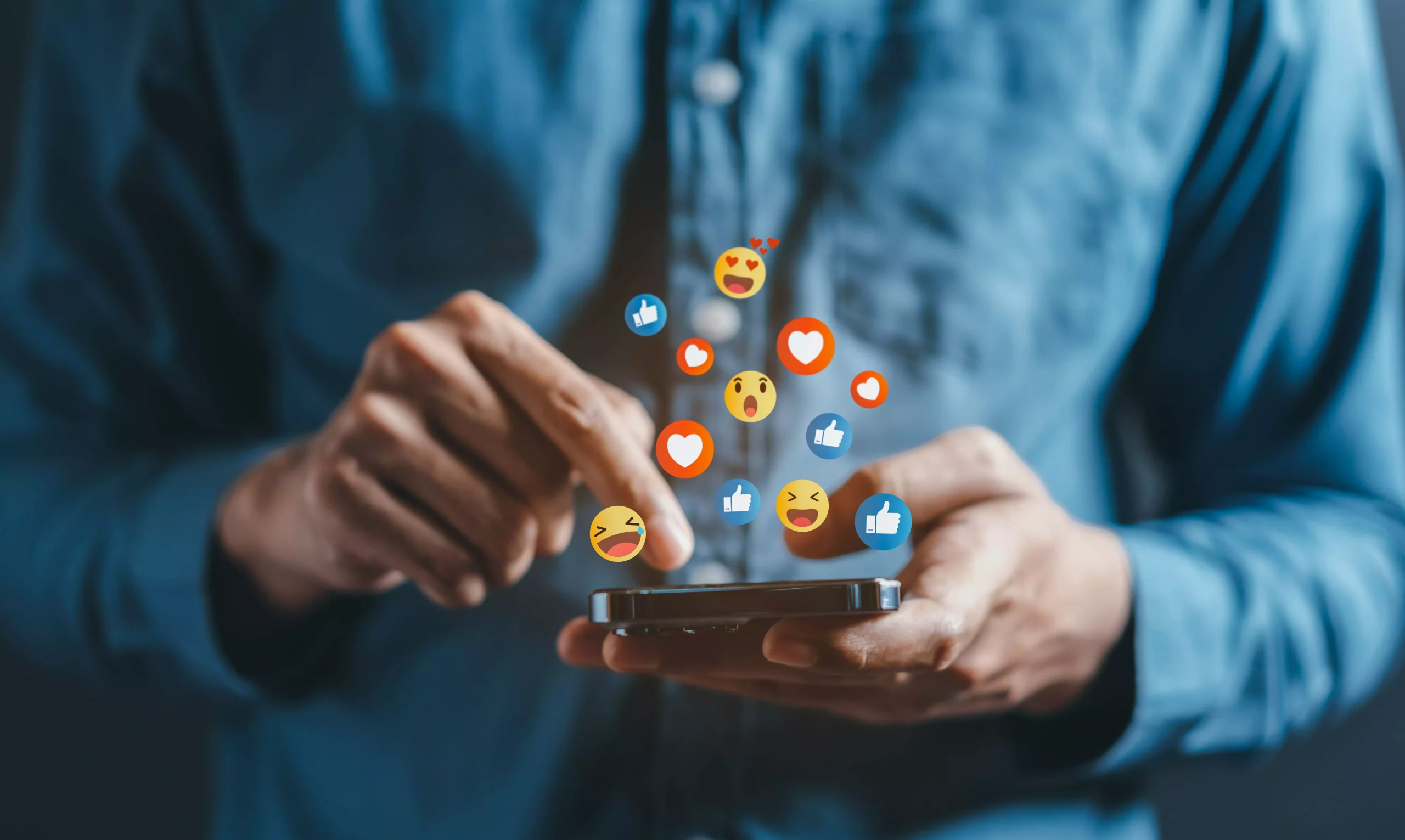 Personne sur son téléphone avec des smiley sortant du téléphone