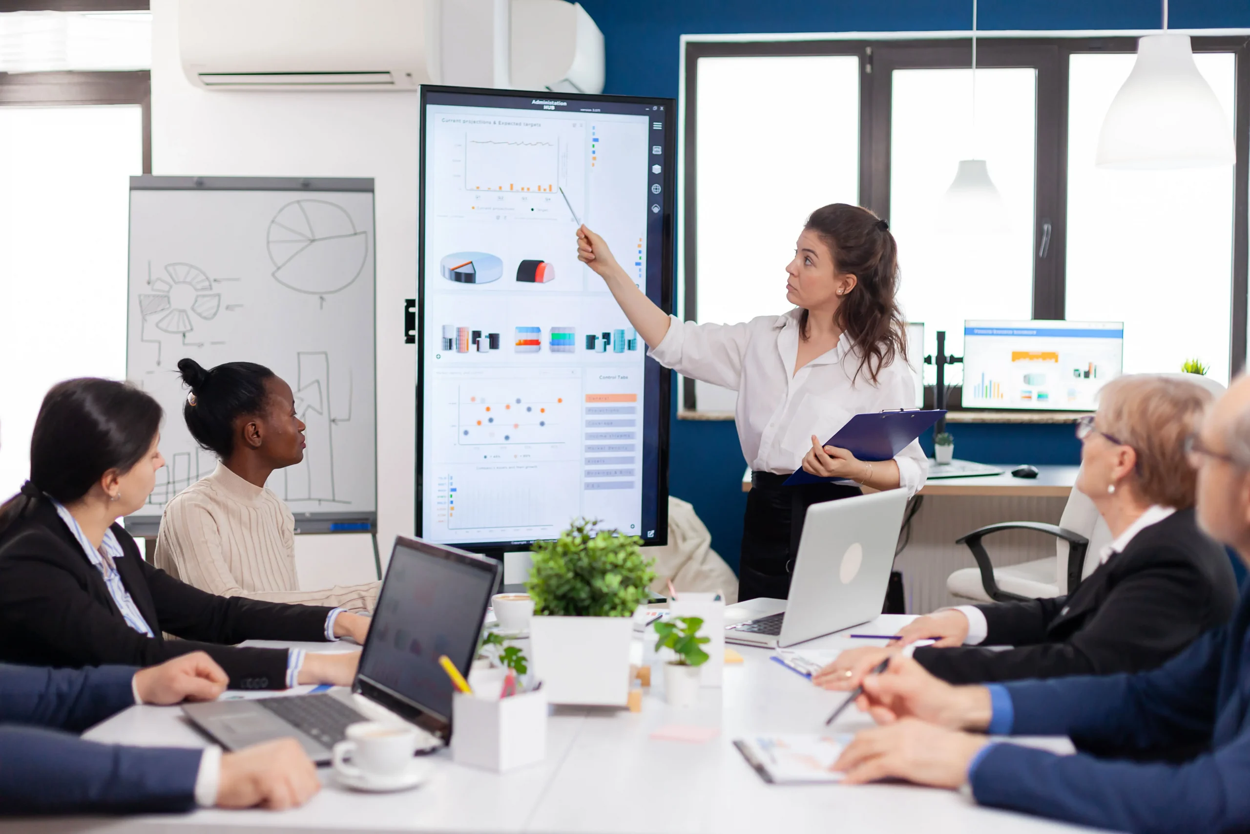 Chef de projet digital présentant à son équipe des diagrammes d'évaluation de la satisfaction des besoins clients.