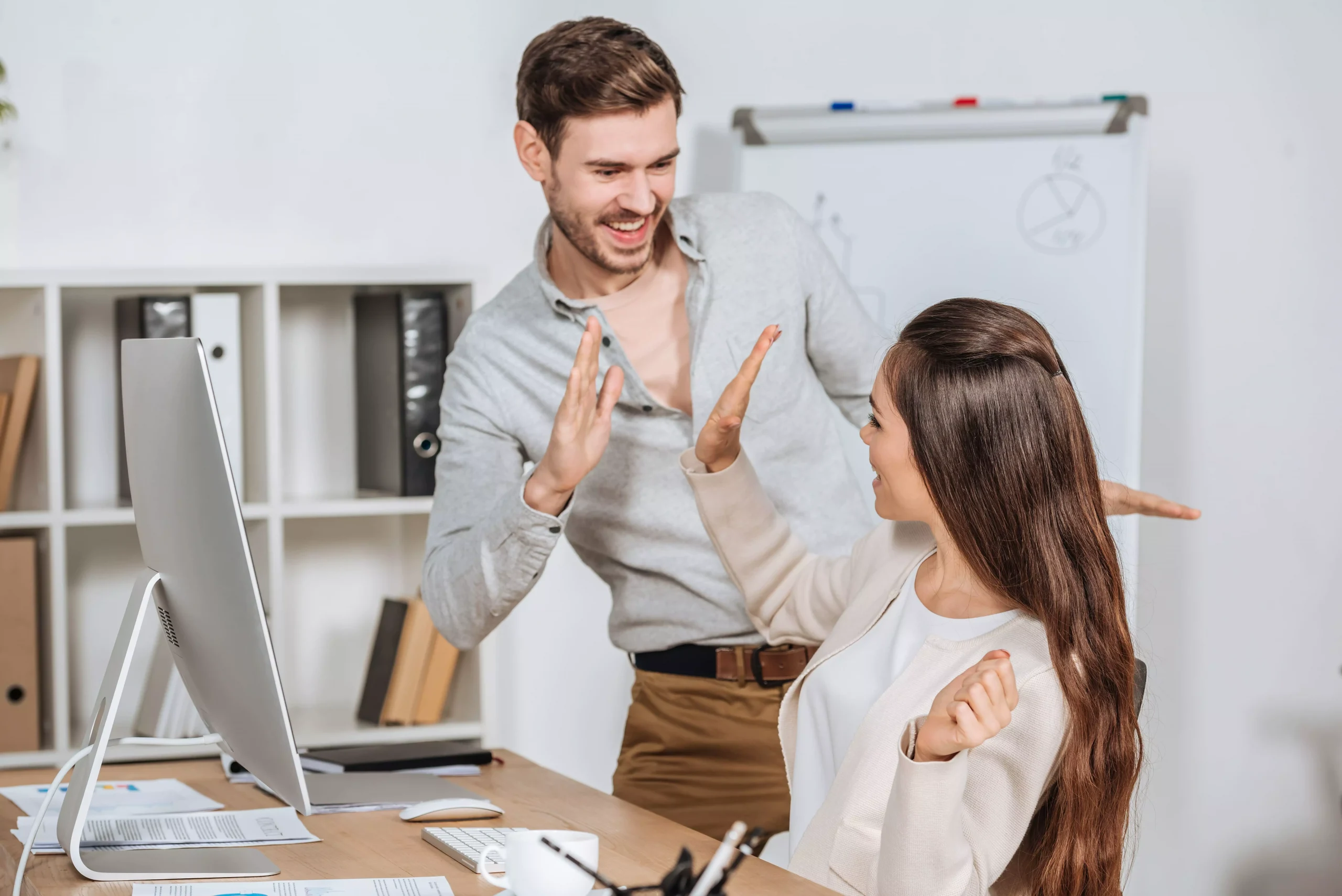 Deux collaborateurs qui se tapent dans la main, heureux de leur travail