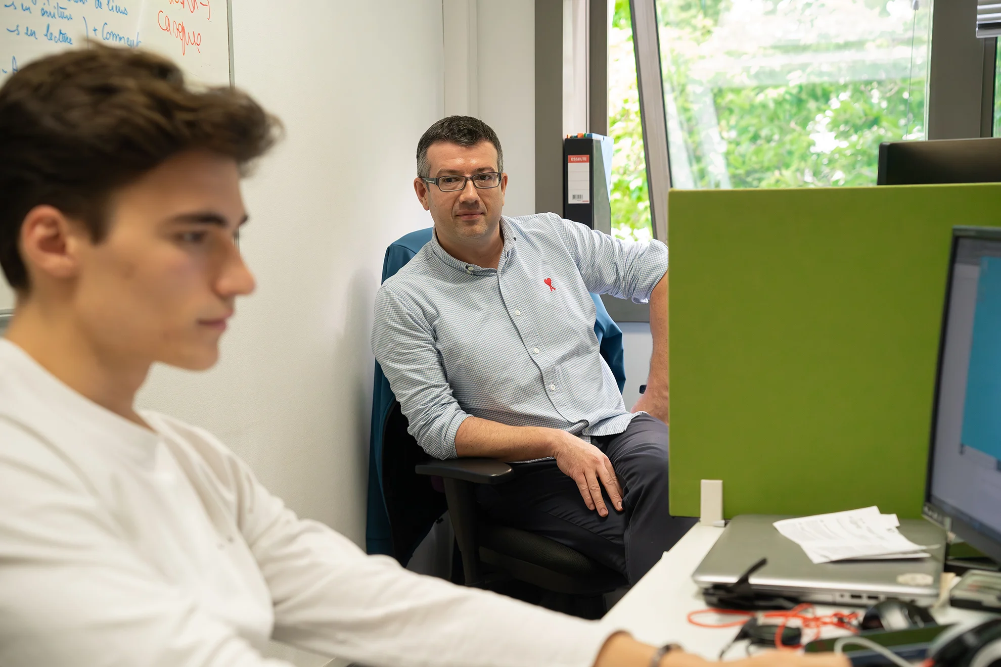 Collègue qui observe le travail d'un alternant