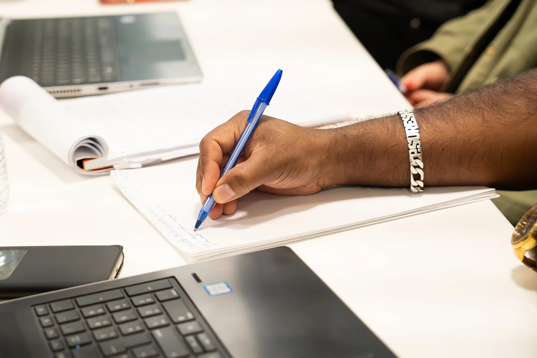 Stagiaire prenant des notes pour retenir les leçons